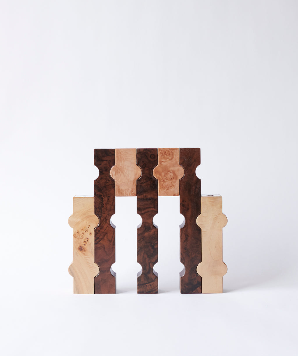 Dark and light wood candles holders which interlock to create a sculpture