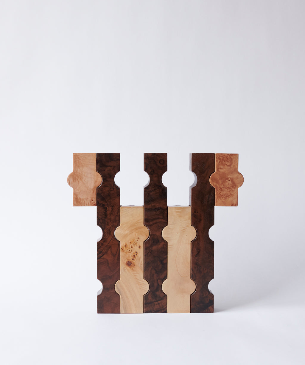 Interlocked sculptural wooden candle holders in contrasting dark and light wood