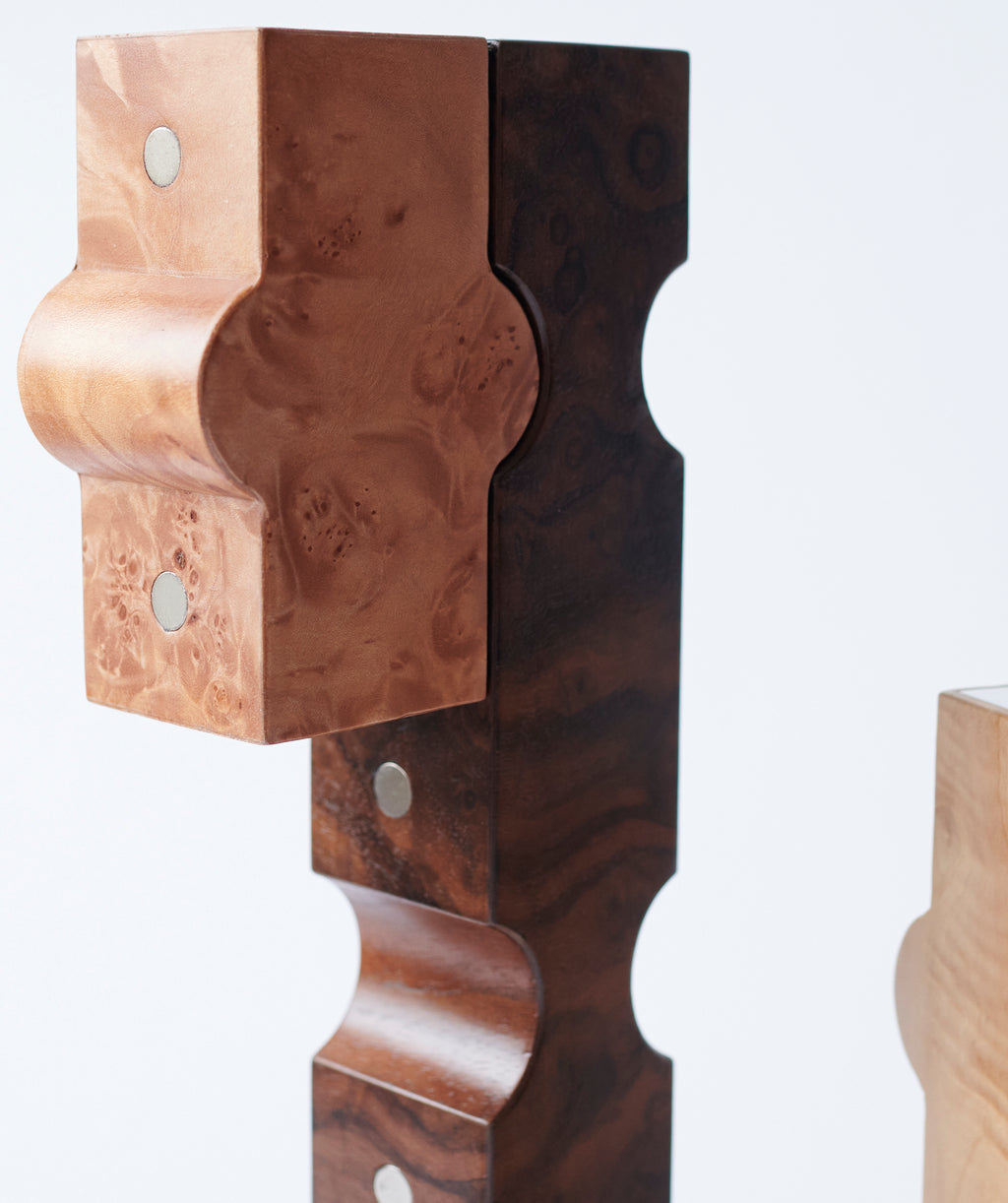 Side view of sculptural wooden candle holders which fit together