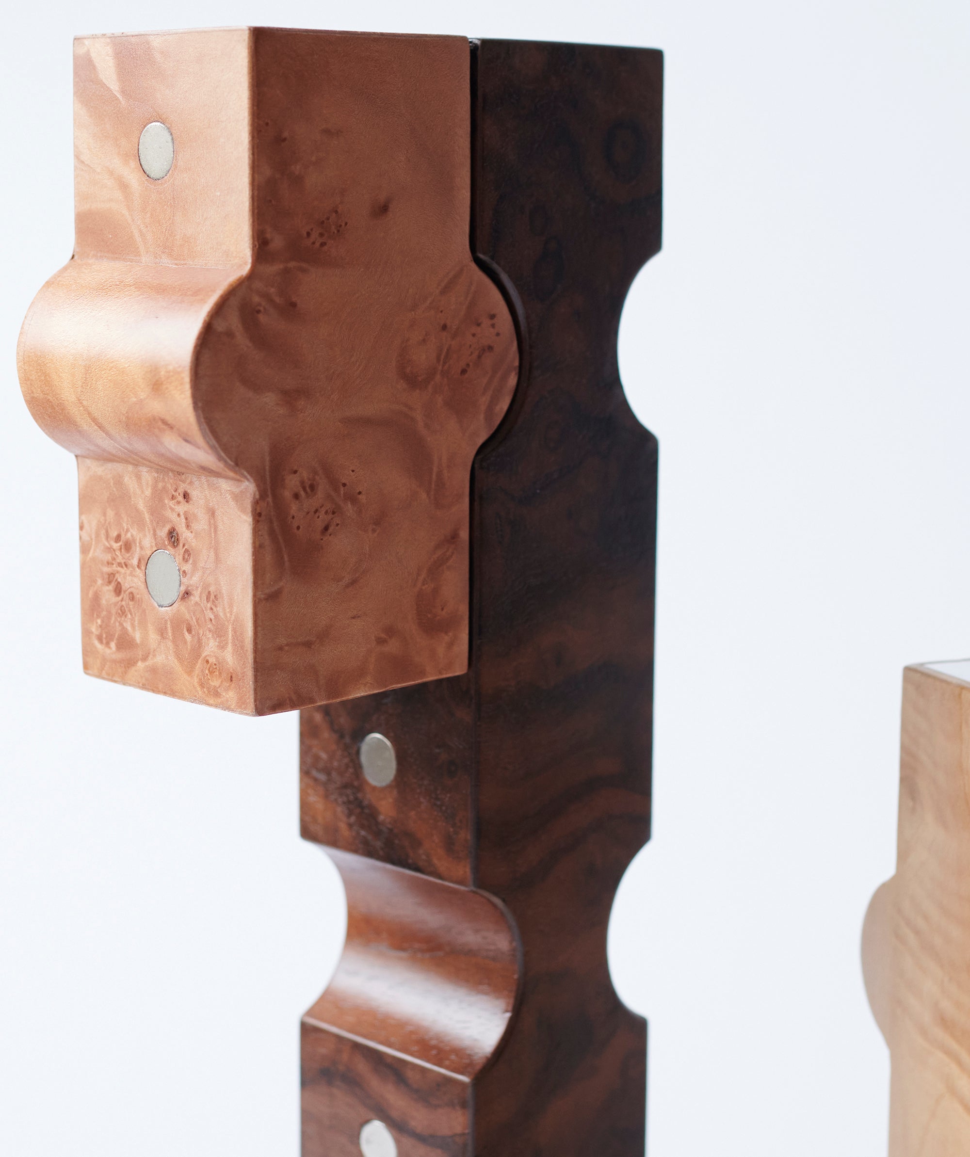 Side view of sculptural wooden candle holders which fit together