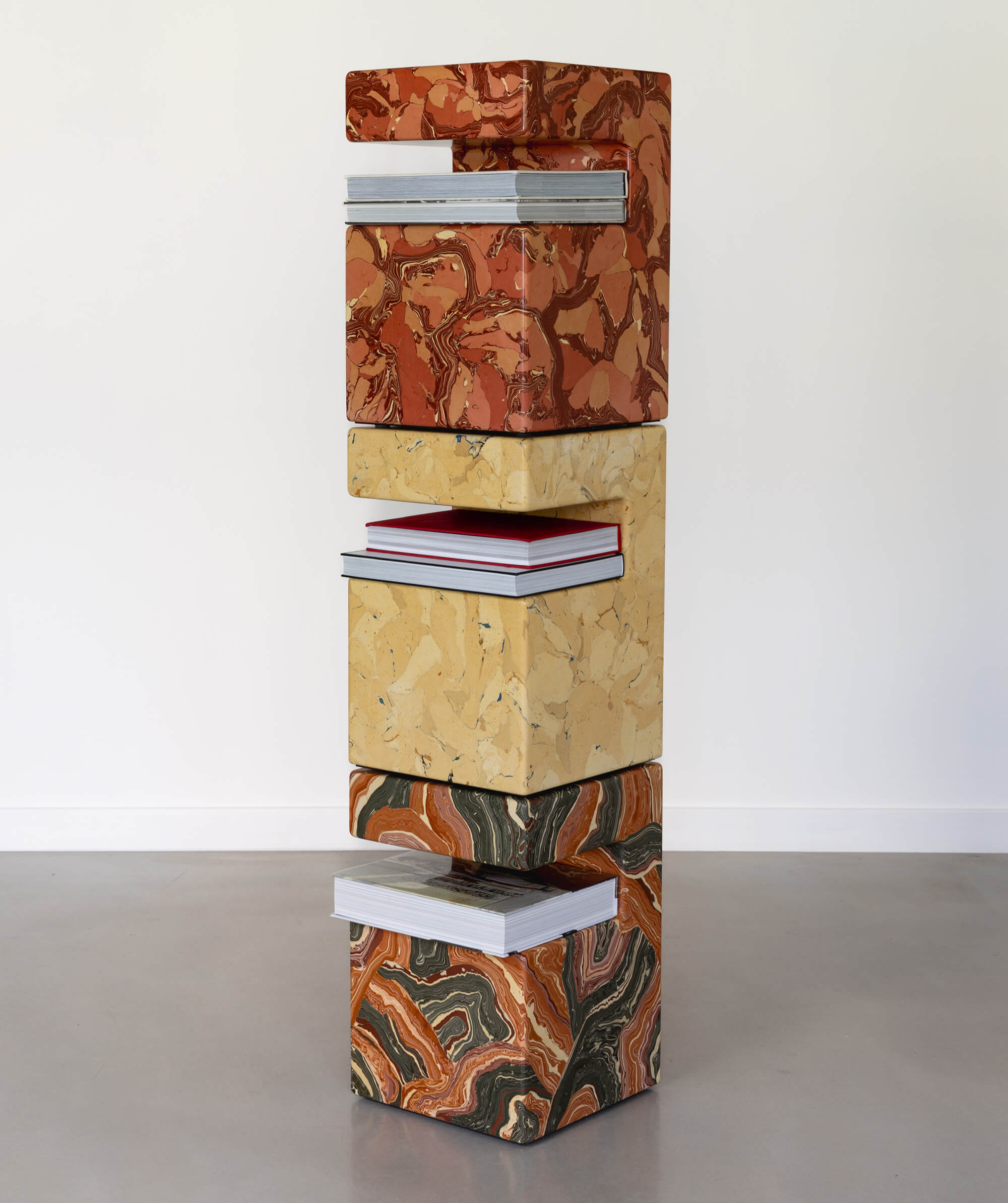 Stack of scagliola block sculptures, holding books